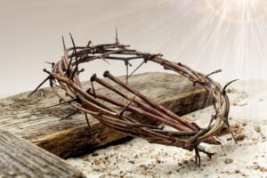crown of thorns and nails laying on a wooden cross