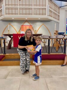 Pastor presenting bible to child
