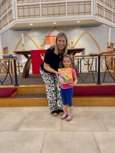 Pastor presenting bible to child